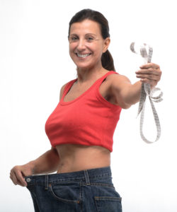 Happy woman in old jeans pant after losing weight